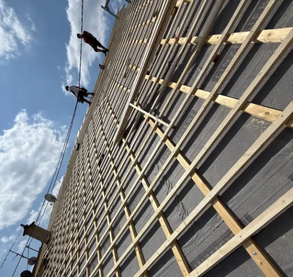 Dachdecker arbeiten an einem Dach in Saarlouis.Sie fangen gerade an, neue Ziegel auf das Dach zu legen 